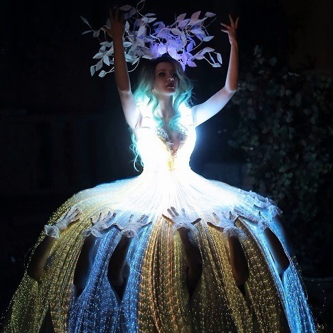 Световое шоу, где вокалистка в большом светящимся платье а девушки под ее юбкой